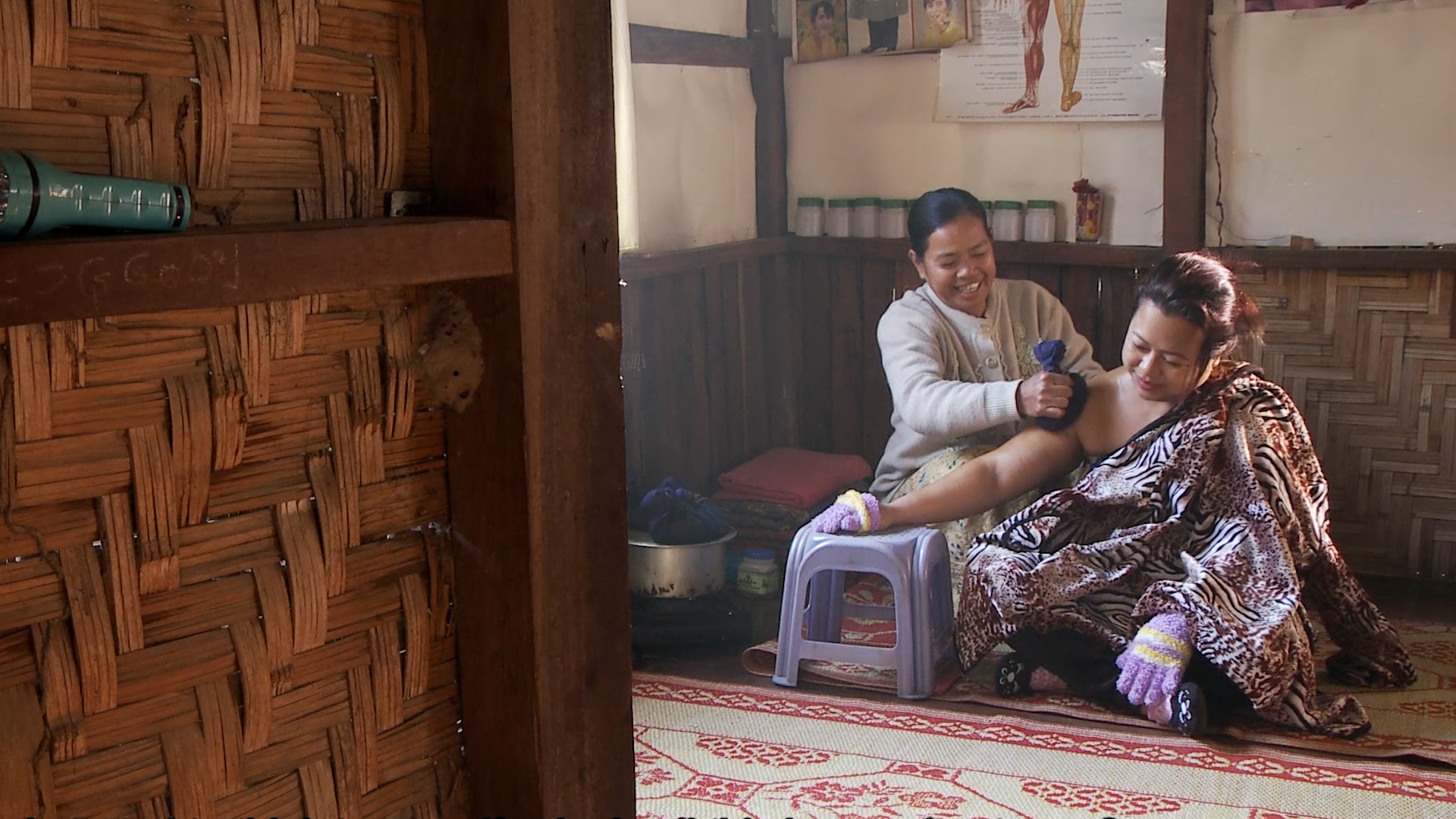 Nyunt Kyi treating a woman in her clinic