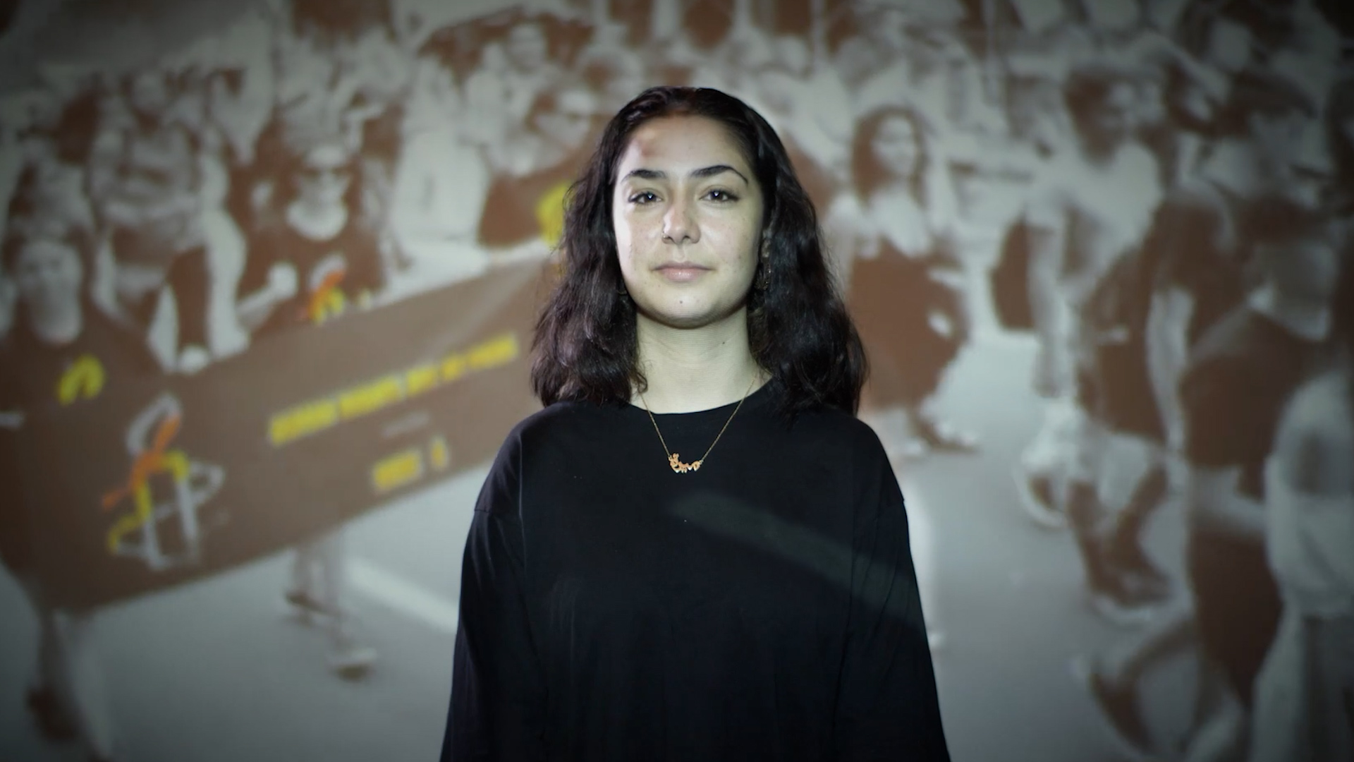 Girl looking at camera with protest imagery behind her